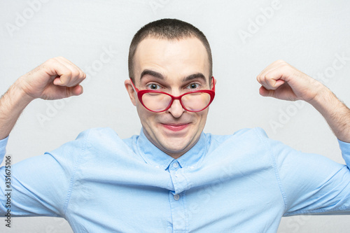 Funny guy shows his strength  guy with red glasses  portrait  white background