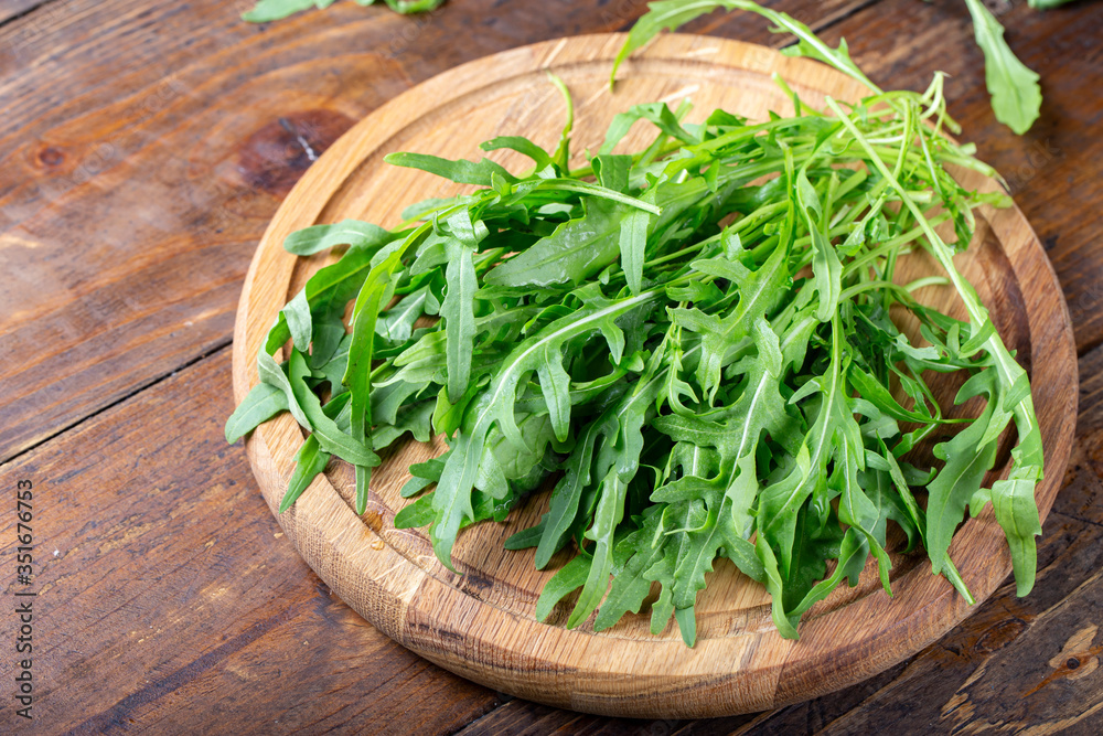 arugula salad on a wooden cutting board arugula salad on a wooden cutting board