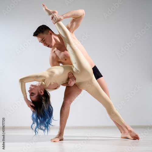 Wallpaper Mural A pair of dancers in action. A young duet of circus artists perform support with twine in the studio. Man in underpants holding Woman in overalls for gymnastics in the splits. Torontodigital.ca