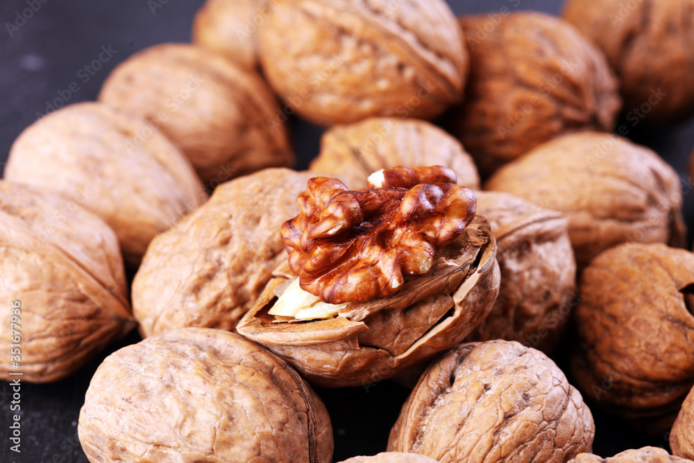 Walnut kernels and group of whole walnuts on rustic old table Walnut kernels and group of whole walnuts on rustic old table
