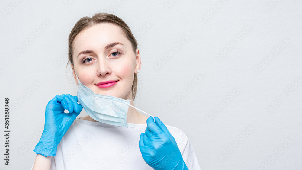 Nurse taking off her medical mask, portrait, close up, white background, copy space, 16:9 Nurse taking off her medical mask, portrait, close up, white background, copy space, 16:9