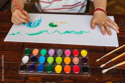 A boy paints a picture with his watercolors at home due to confinement by Covid-19.
