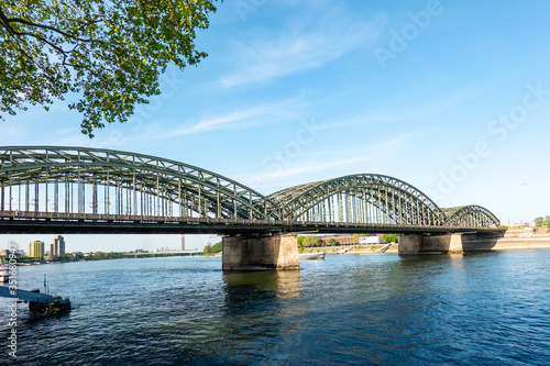 Cologne Koln Köln, Germany, Panoramic View of the Hoenzollern Bridge on Rhein River with Blue Sky © Paola Leone