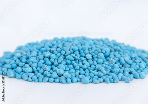 Blue chemical fertilizer on white background.