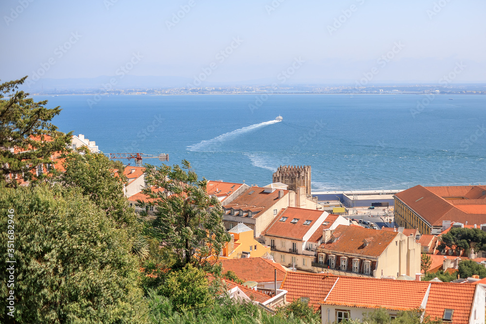 Houses with orange roofs with the sea on the background. Summer in Lisbon. Portugal
