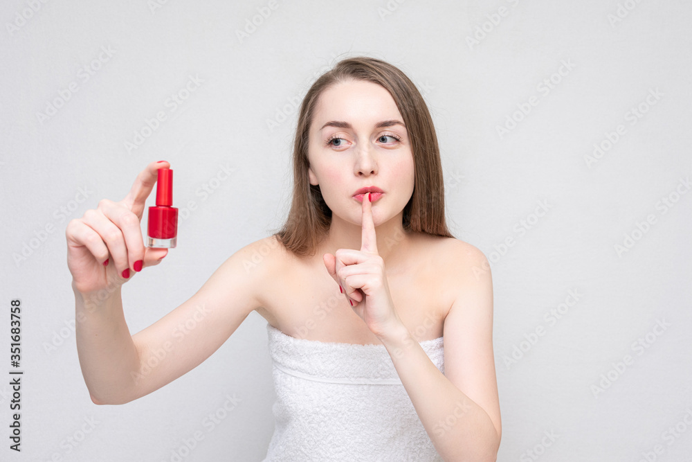 Woman shows red nail polish and makes a sign shh, portrait, white background Woman shows red nail polish and makes a sign shh, portrait, white background