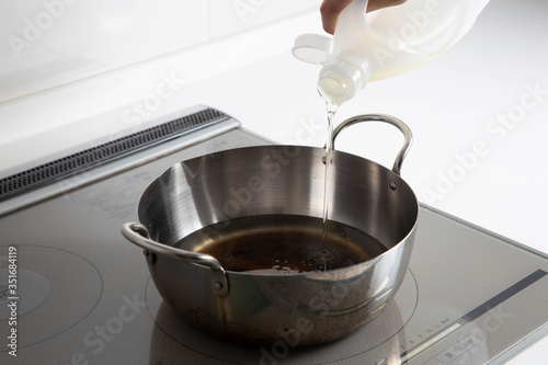 揚げ物　鍋に油を注ぐ　キッチン