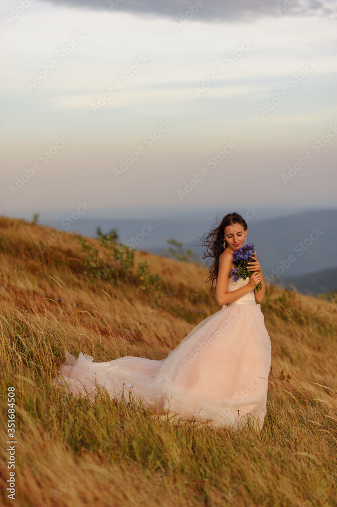 Portrait of a beautiful bride with a bouquet of wildflowers 