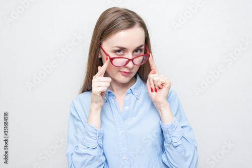 Playful girl took off red glasses  portrait  white background  copy space