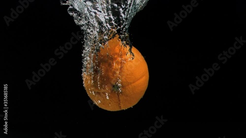 Orange diving in super slow motion into water