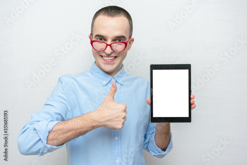 Funny man with tablet shows gesture super, portrait, copy space, white background photo