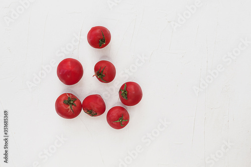 Tomatoes on a white textural background.