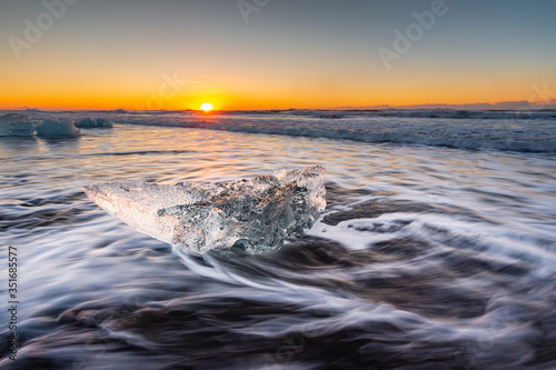 Golden ice on the black beach near Jokulsarlon glacier lagoon, daimond beach, South Iceland.