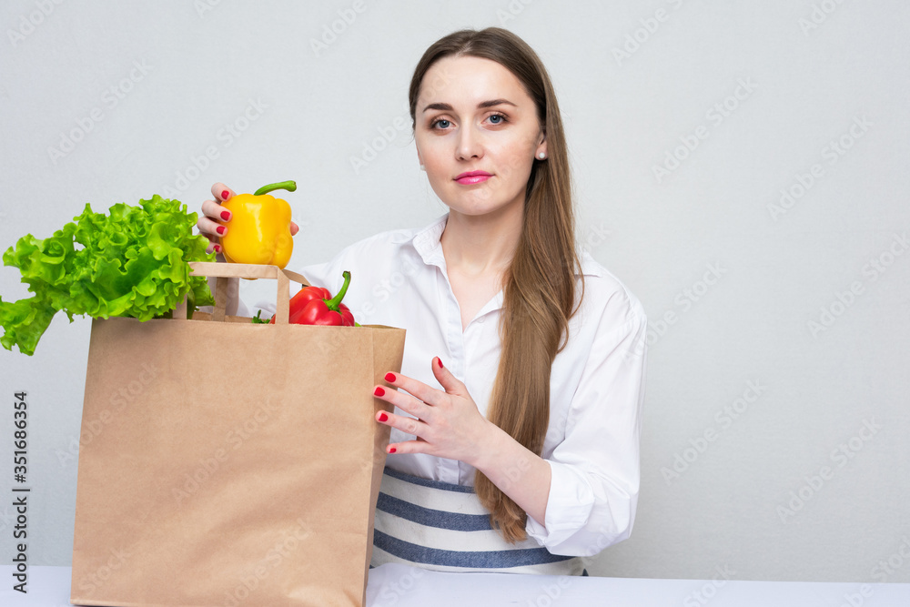 Girl with grocery paper shopping bag full of fresh vegetables, concept of vegan lifestyle Girl with grocery paper shopping bag full of fresh vegetables, concept of vegan lifestyle