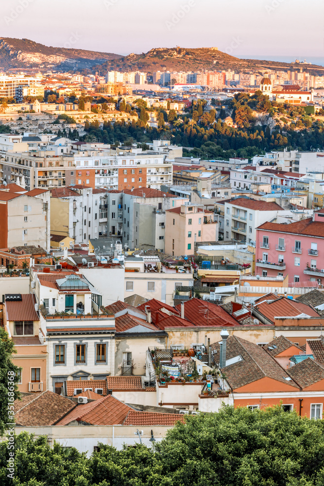 Cagliari, capital of Sardinia (Sardegna), Italy. Aerial view of the city. Colourful cityscape at golden hour, vertical photo.