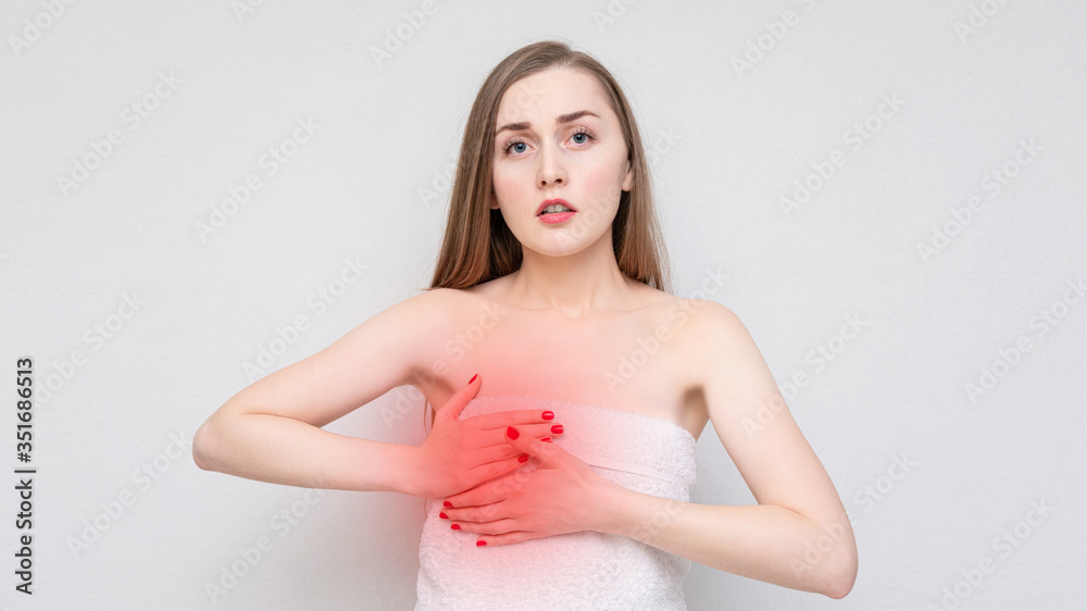 Girl has chest pain during pms, unhappy woman looking at the camera. Concept of mastitis, portrait, white background, copy space, 16:9 Girl has chest pain during pms, unhappy woman looking at the camera. Concept of mastitis, portrait, white background, copy space, 16:9