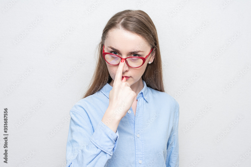 Young girl nerd adjusts her red glasses, portrait, white background