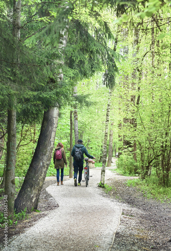 Two young people are walking on a path in a park