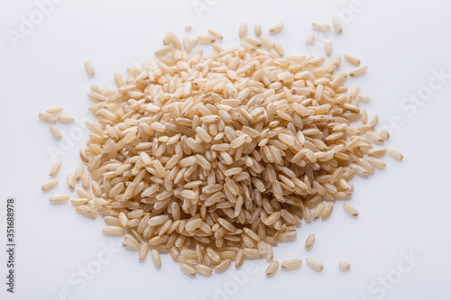 raw brown rice on white acrylic background