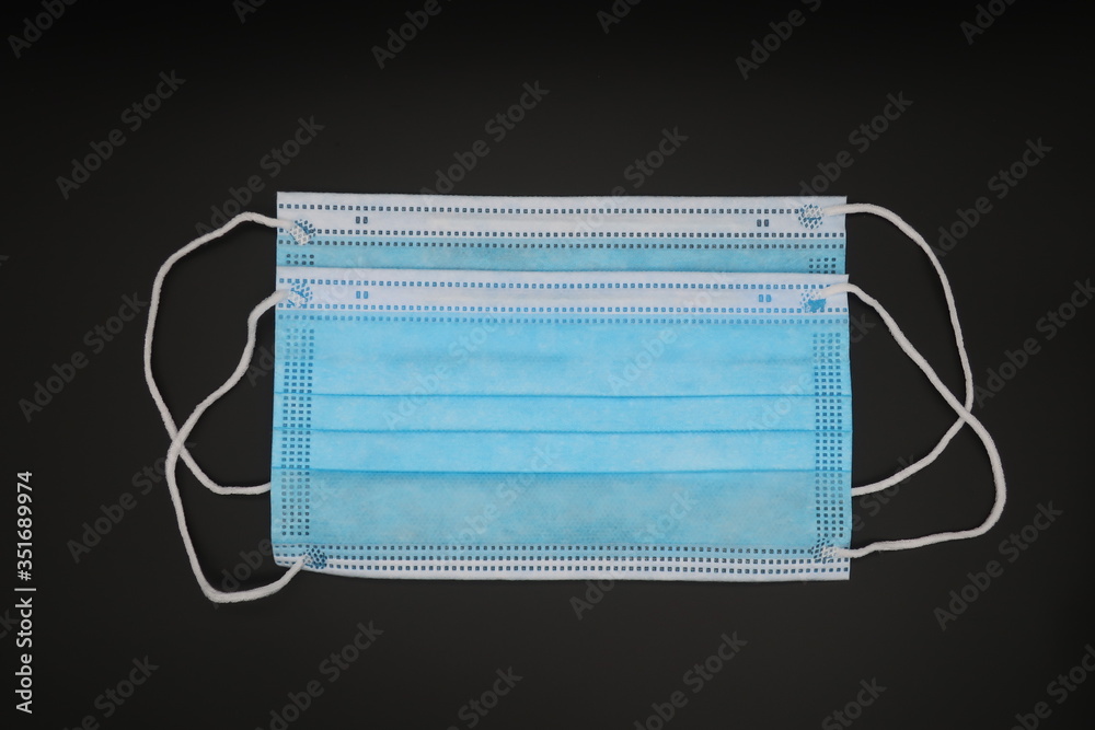 Obraz premium blue medical face masks on black background