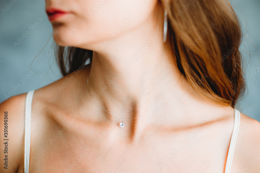 Beautiful slim neck of a young caucasian girl with jewelry. Shallow focus. Bokeh Beautiful slim neck of a young caucasian girl with jewelry. Shallow focus. Bokeh