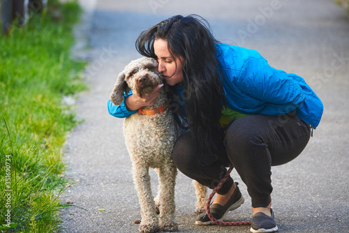 Woman hugging dog (Lagotto romagnolo) photo