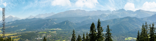 high tatra mountain ridge. poland travel destination. beautiful summer panoramic landscape in evening light. sunny weather with fluffy clouds on the blue sky.