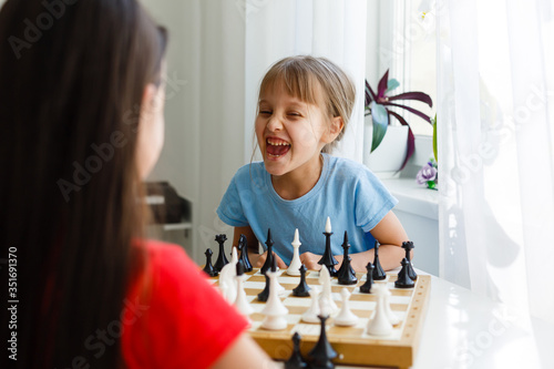 Two little sister playing chess at home