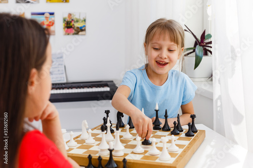 Two little sister playing chess at home
