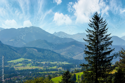 high tatra mountain ridge. poland travel destination. beautiful summer landscape in evening light. sunny weather with fluffy clouds on the blue sky.