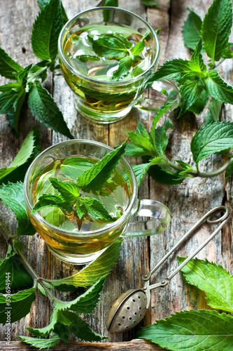 Two glass cups with fresh mint tea on wooden table