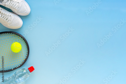 Summer sport tennis concept, tennis  ball , racket  sneakers and bottle of water . Top view, copy space, flat lay . 