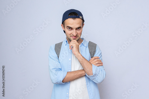 Принти на полотні Evil teen guy with the backpack, gray background, copy space