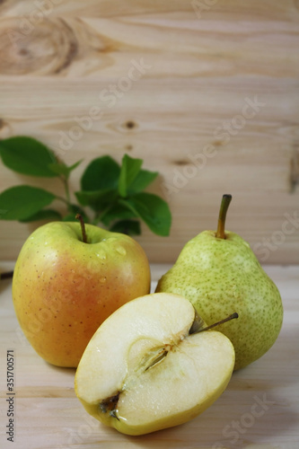 Pear, apple and sliced apple on a wooden table