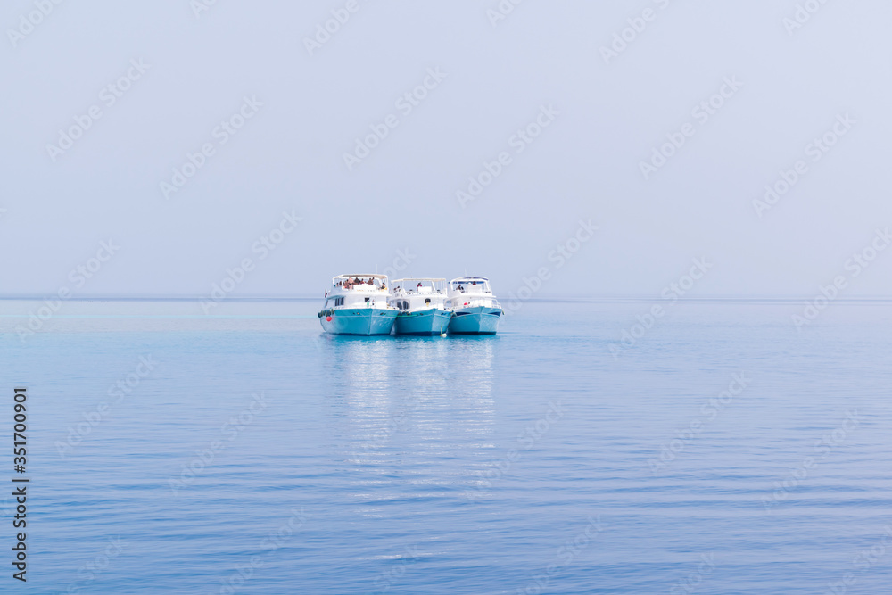 Boats yachting in the blue sea, ships in calm open ocean