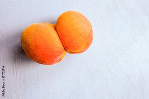 An ugly organic fruit-an oddly shaped yellow apricot on a white background. Buying imperfect products is a way to deal with food waste. Copy space