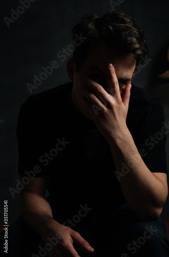 young and handsome man in studio lighting shows emotions © Oleksandr