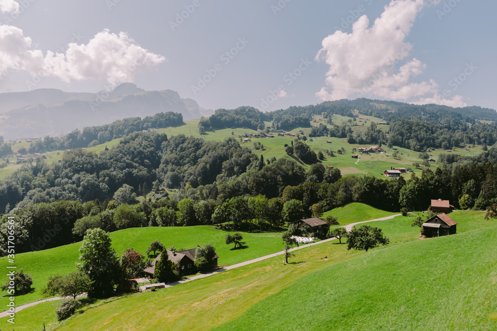 summer green countryside village scenery. summer green countryside village scenery with hills and houses in Switzerland.
