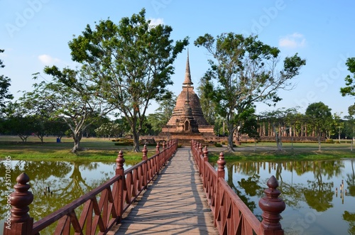 Canvas Print A red bridge is leading to Wat Sra Sri, a beautiful temple in the historical par