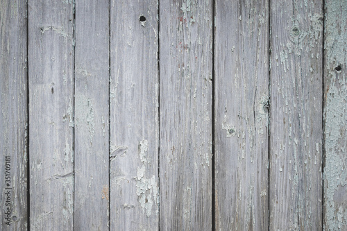 Closeup of an old texture of a weathered wooden wall painted in turquoise color. Aged wooden plank fence made of flat table boards. Copy space.