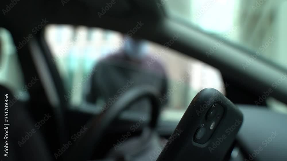 Burglar stealing a smart phone from the car on a parking in the city Burglar stealing a smart phone from the car on a parking in the city