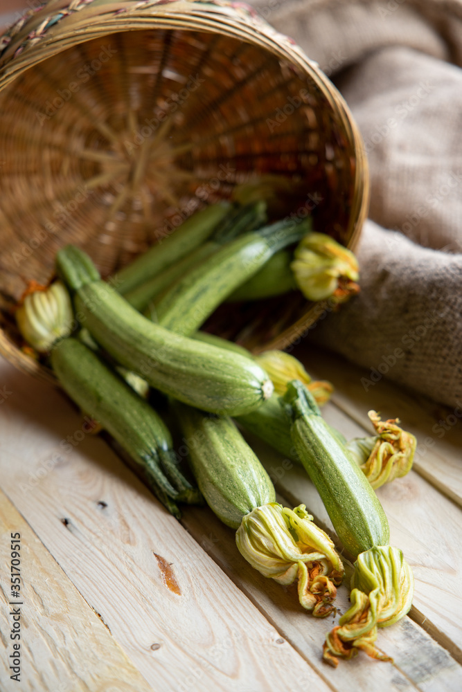 Fresh zucchini or green courgette, farm fresh produce, summer squash on a wooden table Fresh zucchini or green courgette, farm fresh produce, summer squash on a wooden table