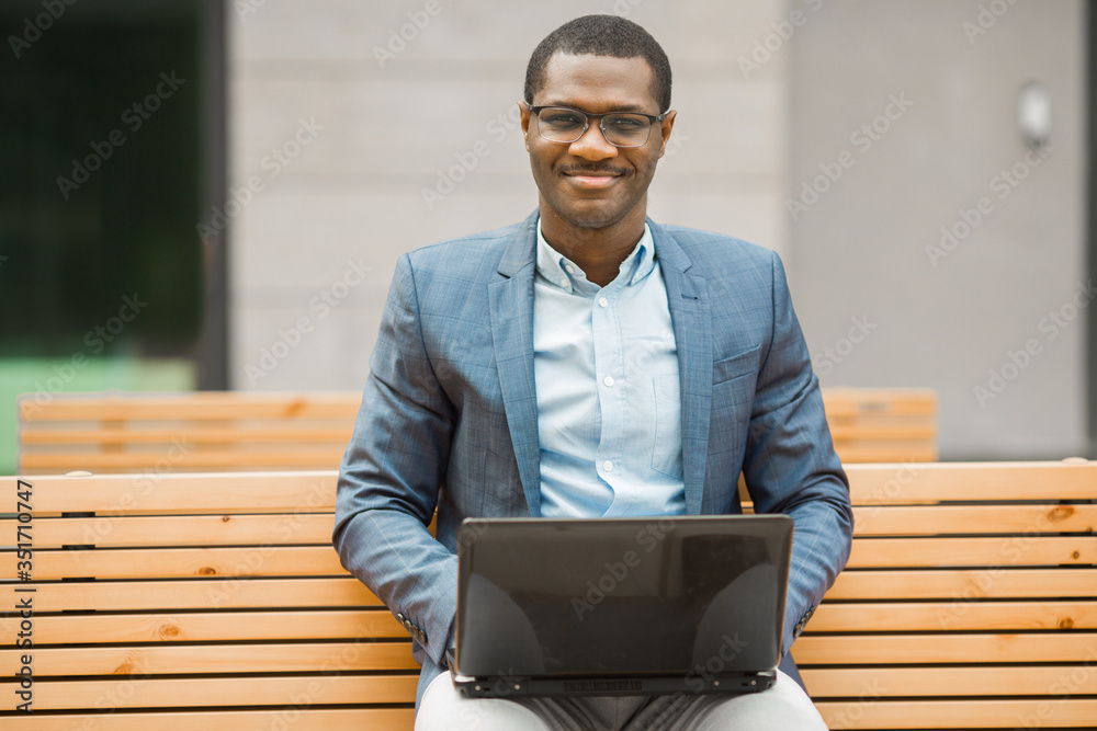 handsome young african man sitting with laptop handsome young african man sitting with laptop