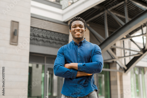 handsome young african man stands near a building
