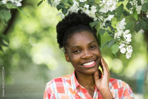 beautiful young african woman near a flowering tree