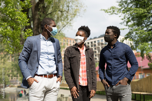 team of young african people in summer on a walk in the park in protective face masks