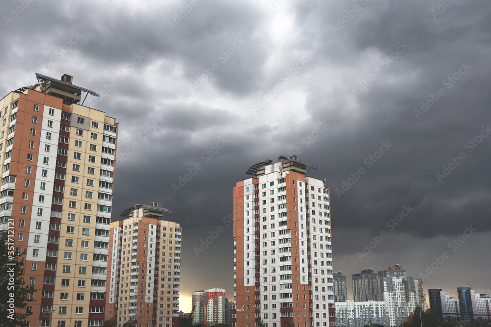 Fototapeta premium Houses on a background of gloomy stormy sky. Concept of crisis and problems.