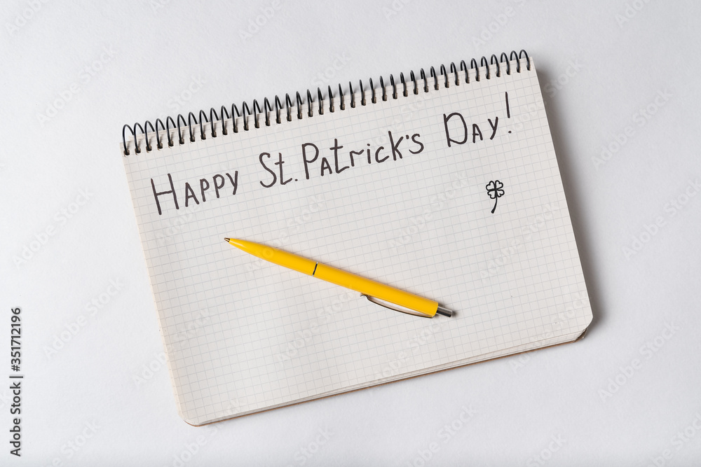 Notebook with words HAPPY St PATRICKS DAY. Top view, white background Notebook with words HAPPY St PATRICKS DAY. Top view, white background