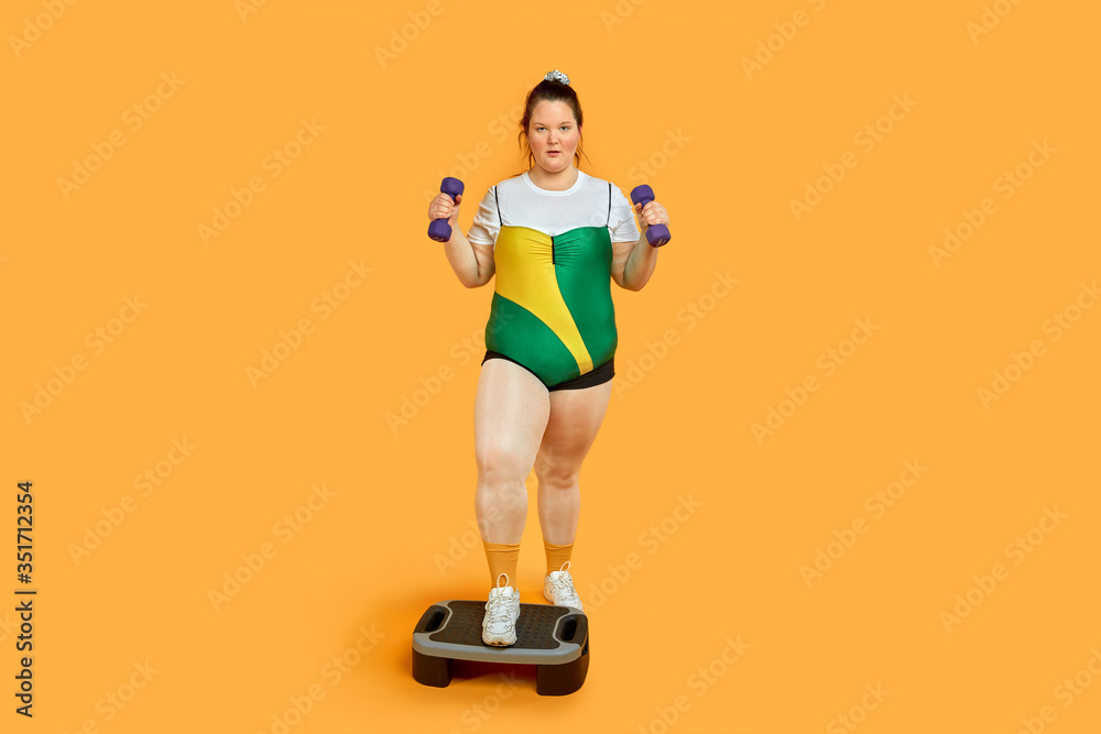 Bright cheerful fat girl is engaged in sports and looks at the camera. Bright cheerful fat girl is engaged in sports and looks at the camera.