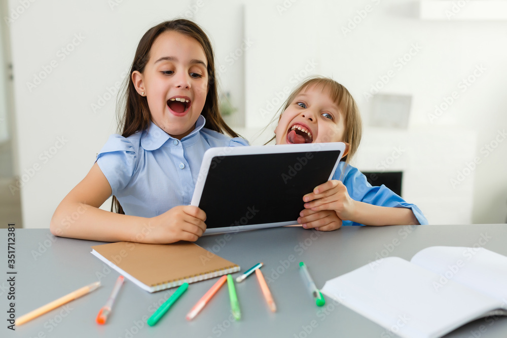 Pretty stylish schoolgirls studying during her online lesson at home, social distance during quarantine, self-isolation, online education concept Pretty stylish schoolgirls studying during her online lesson at home, social distance during quarantine, self-isolation, online education concept